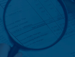 image: magnifying glass looking at profit report